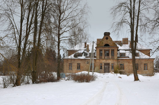 Old yellow brick administration house in the Polish style in Loiki village, Grodno region, Belarus in winter.