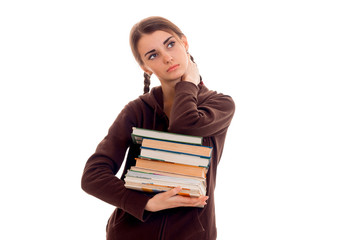 Teen girl with pigtails in the jacket looks up and holds a lot of books