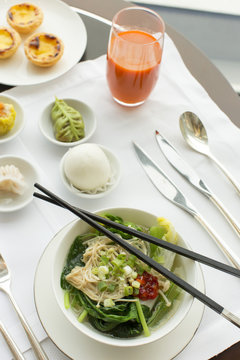 Vegetable and noodle dish on table with chopsticks