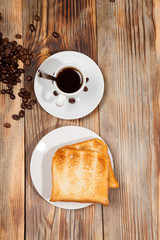 Breakfast, toast and coffee on a wooden background