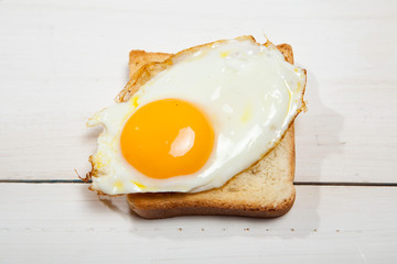 Toasts and egg on a white wooden table