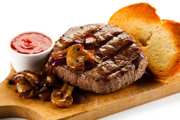 Grilled steak and toasts on wooden board