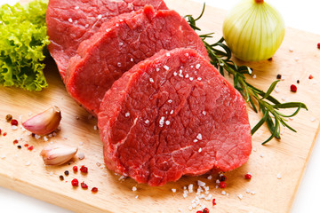 Fresh raw steaks on wooden desk