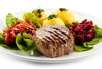 Grilled steaks, boiled potatoes and vegetable salad on white background