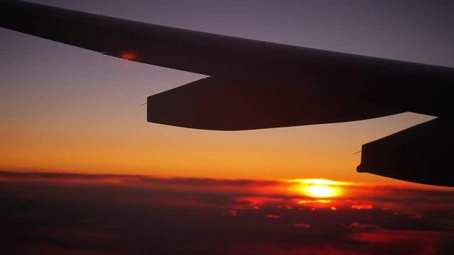 Airplane wing in flight at sunset