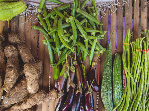 Sweet potato and eggplant with other vegetables on wood table. Farm market in tropical country.