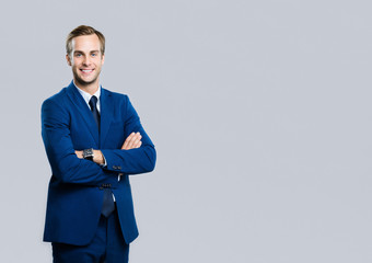 smiling young businessman, on grey