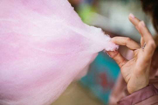 Person taking a piece of cotton candy