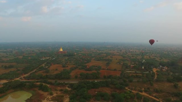 Landscape view of Bagan archaeological zone with balloons over from hot air balloon in Myanmar.