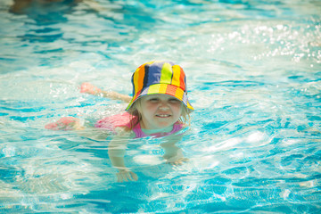 Fototapeta na wymiar Cute little child swimming in pool