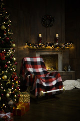 Red chair near the fireplace and Christmas tree