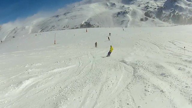 Snowboarder rushing down mountain slope covered with snow, extreme winter sports