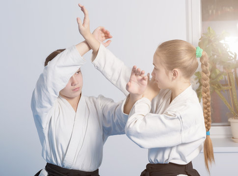 Two girls practice Aikido on martial arts training