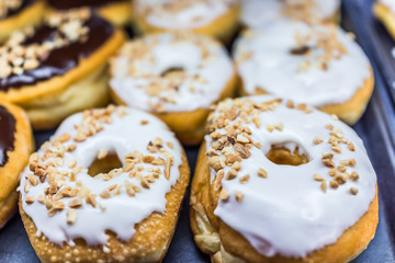 White iced donuts with chopped peanuts
