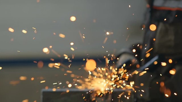 Welding at Large Workshop Agaist Worker in Uniform