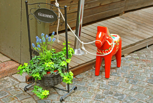 Inscription "Welcome" and a hand-made traditional wooden Dalecarlian Horse at the entrance to the little shop in Gamla Stan, Stockholm, Sweden