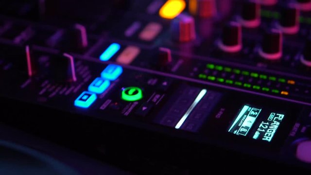 Closeup of DJ equipment deck and mixer with vinyl record