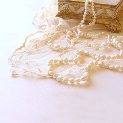 Fototapeta na wymiar white delicate lace fabric and white pearls