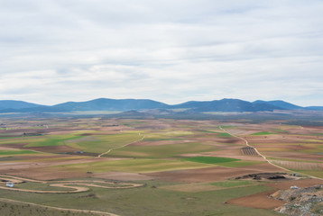 A view from a hill to fields, farms and mountains near Consuegra town at spring cloudy day.