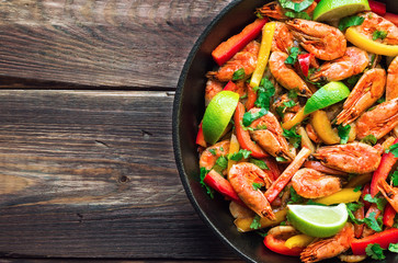 Fried shrimps with bell peppers, cilantro and lime