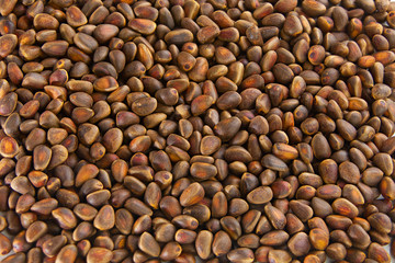pine nuts and pine cone on wooden table
