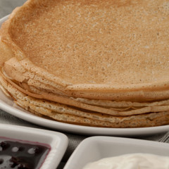 crepes on a plate offered with sour cream and jam