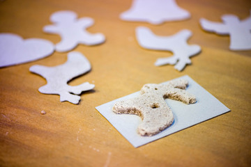 Christmas baking background with salt dough, cookie templates. Baking gingerbread cookies. Kids having fun, making reindeers, stars, angels, hearts from dough. Decorations for christmas tree.