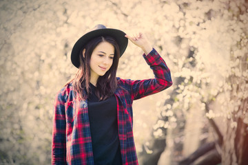 beautiful young woman standing in front of wonderful blooming trees