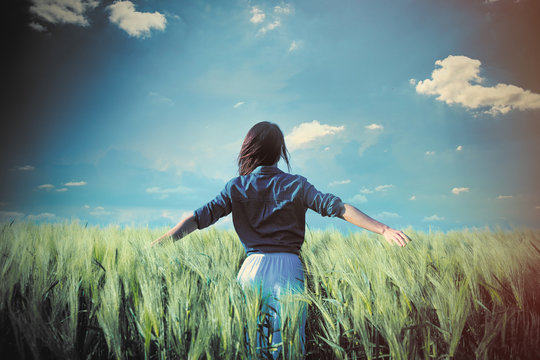 beautiful young woman standing in the middle of the wonderful green field