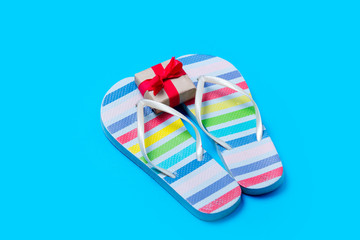 colorful sandals and cute small gift on the wonderful blue background