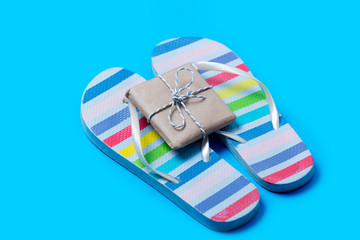 colorful sandals and cute small gift on the wonderful blue background