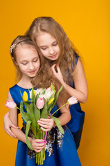 Two beautiful young girl with a bouquet of flowers