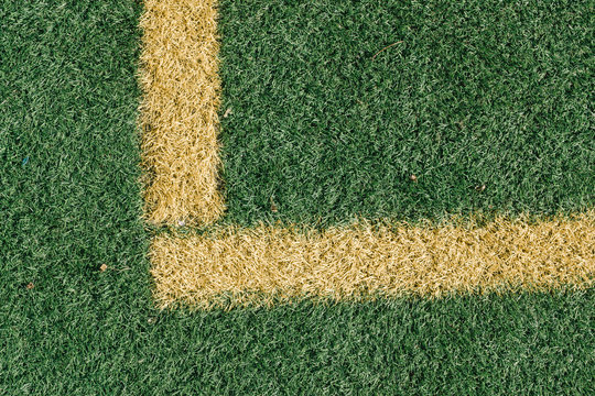 Yellow corner on football field with artificial grass