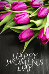 Women's day card. Tulip bouquet on black wooden background