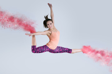 Woman in jump. Frozen motion. Photo manipulation of disintegration