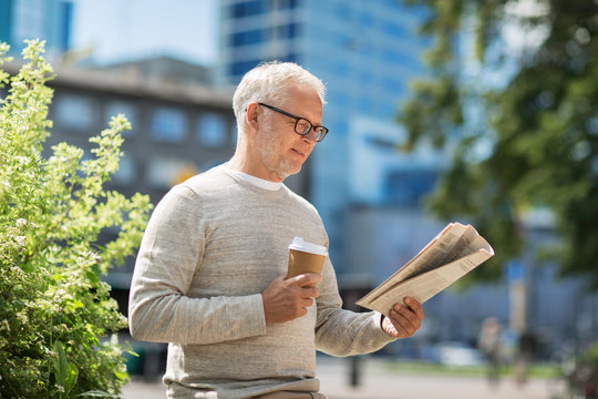 Senior Man Reading Newspaper And Drinking Coffee