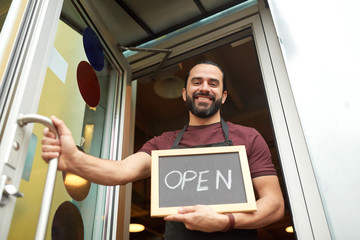 man or waiter with blackboard at bar entrance door