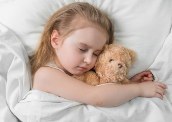 Child sleeping with a cute teddy bear