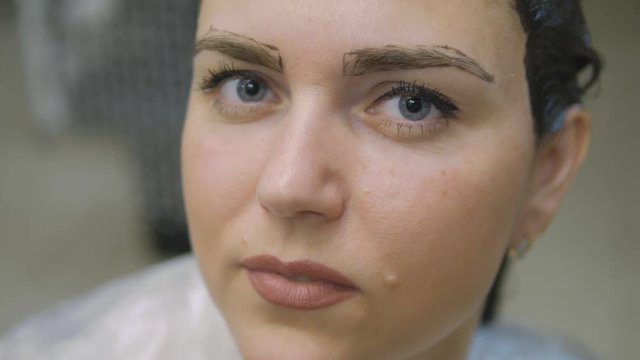Young woman with hair in the paint, to eyebrow make-up sitting from the master image maker beauty salon ultra HD