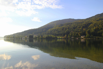 Fototapeta premium Travel to Attersee, Austria. The view on the lake with the mountains on the background in the sunny day.