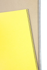 Yellow note book cover and brown note book on white background