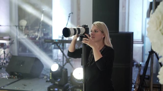 Young woman shooting photo and video on the party indoors