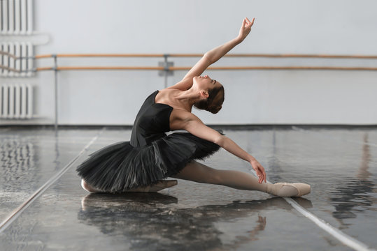 Fototapeta Beautiful ballerina sit on the twine in class