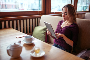 Young woman using tablet pc in cafe.