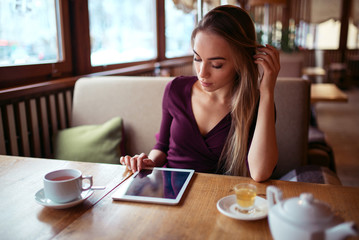 Obraz na płótnie Canvas Woman with tablet pc using internet in restaurant.