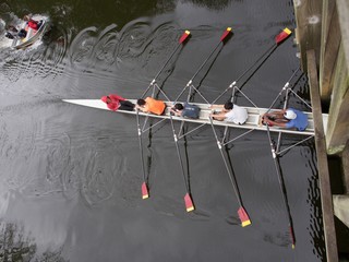 Young people learning to row a scull down the river