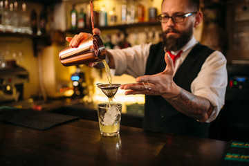 Barman flaring behind bar counter