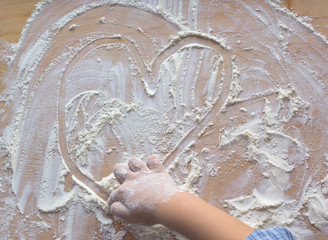 dziecko rysujące serce na mące © winiar