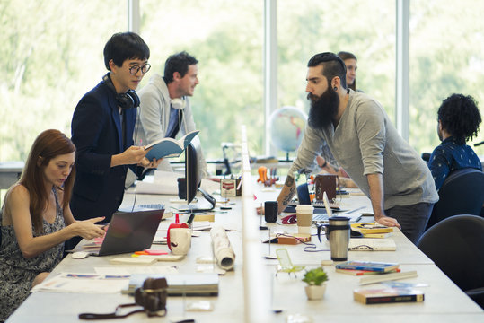 Colleagues working together in open plan office