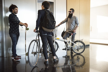 Colleagues chatting while waiting for elevator